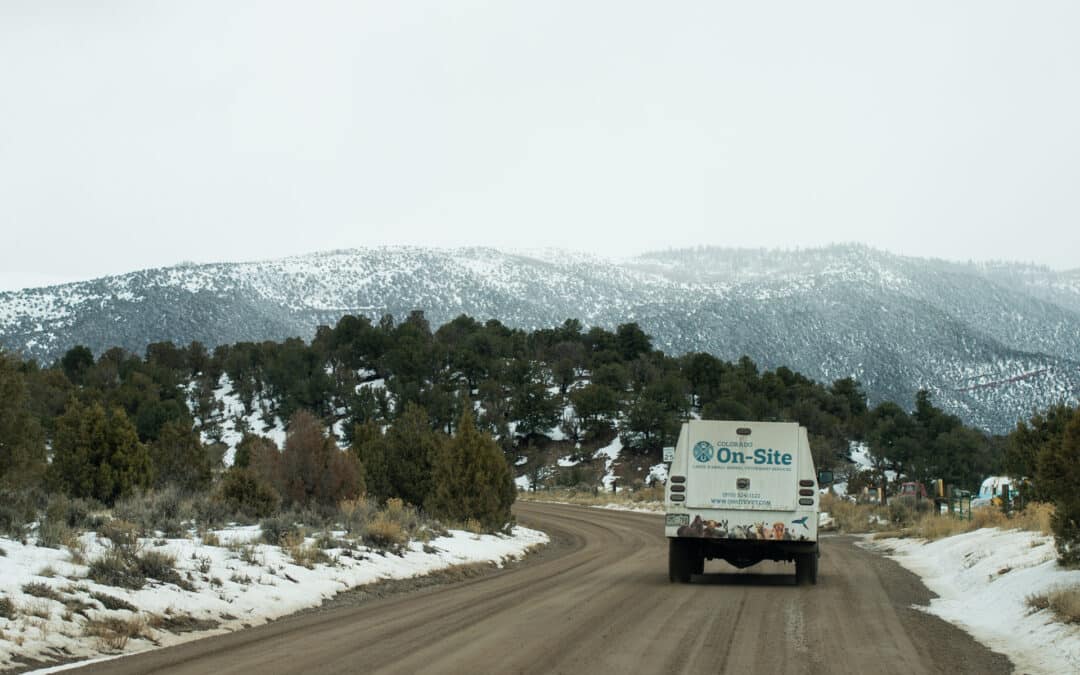 An On-Site Vet vehicle driving towards mountains.